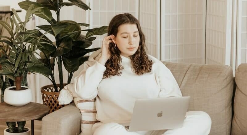 woman in white long sleeve shirt sitting on white sofa